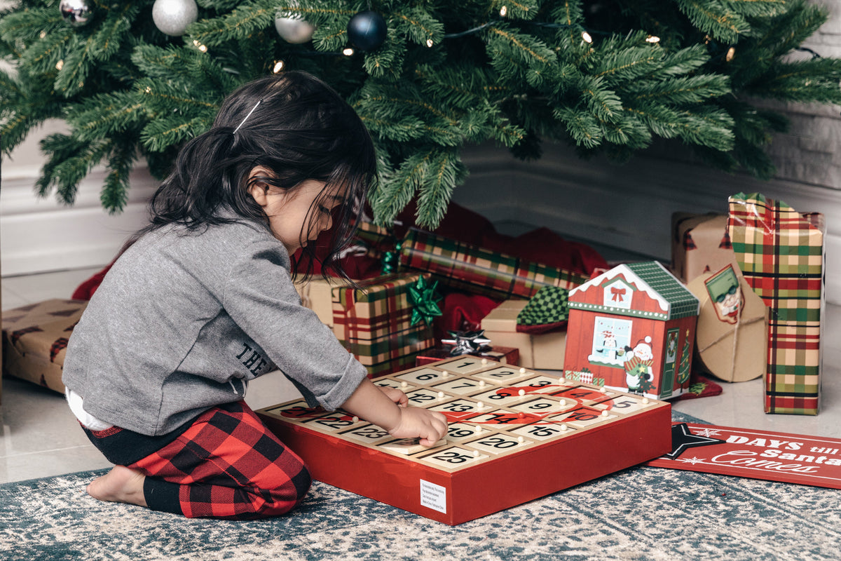 Child opening a gift under the Christmas tree