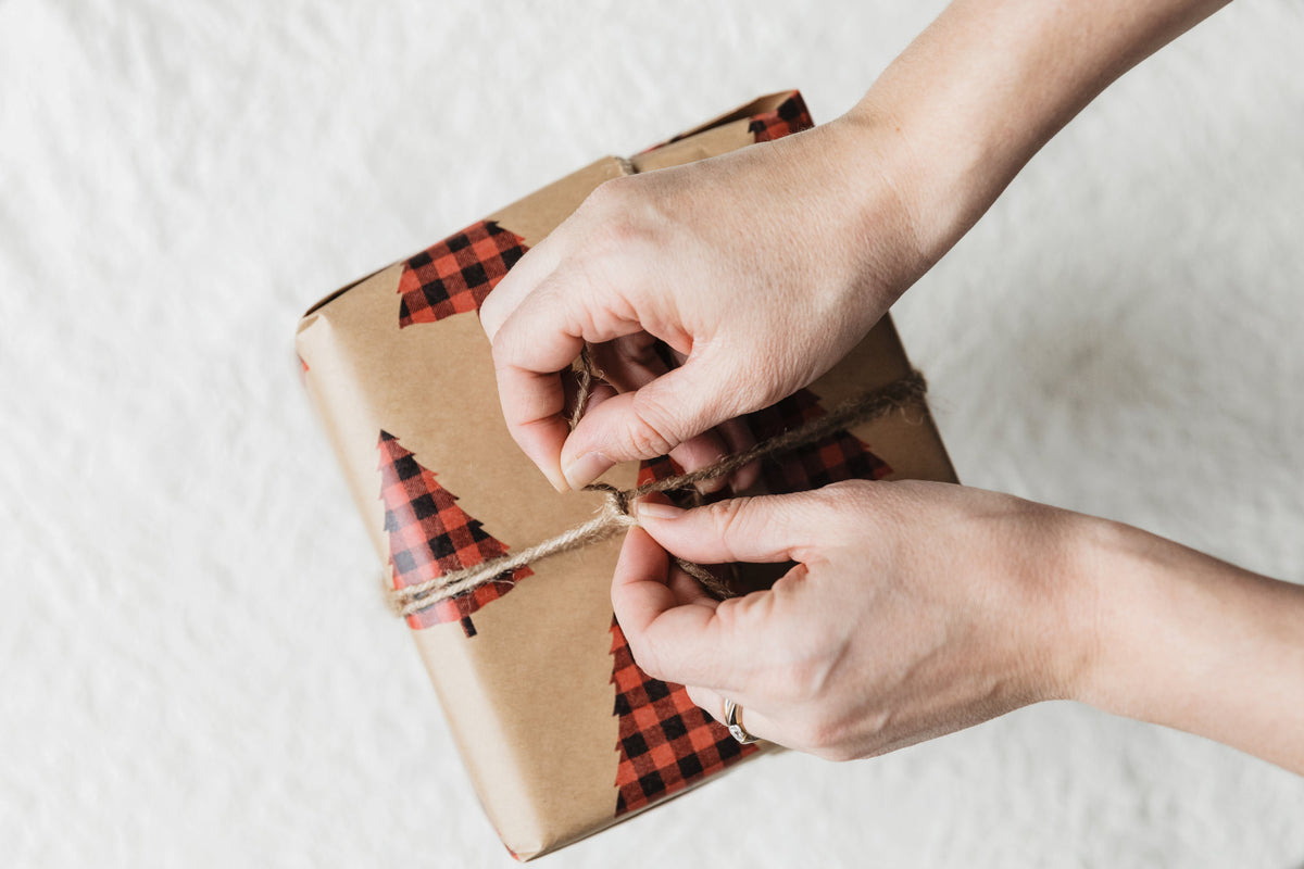 Hand tying twine on a small holiday gift